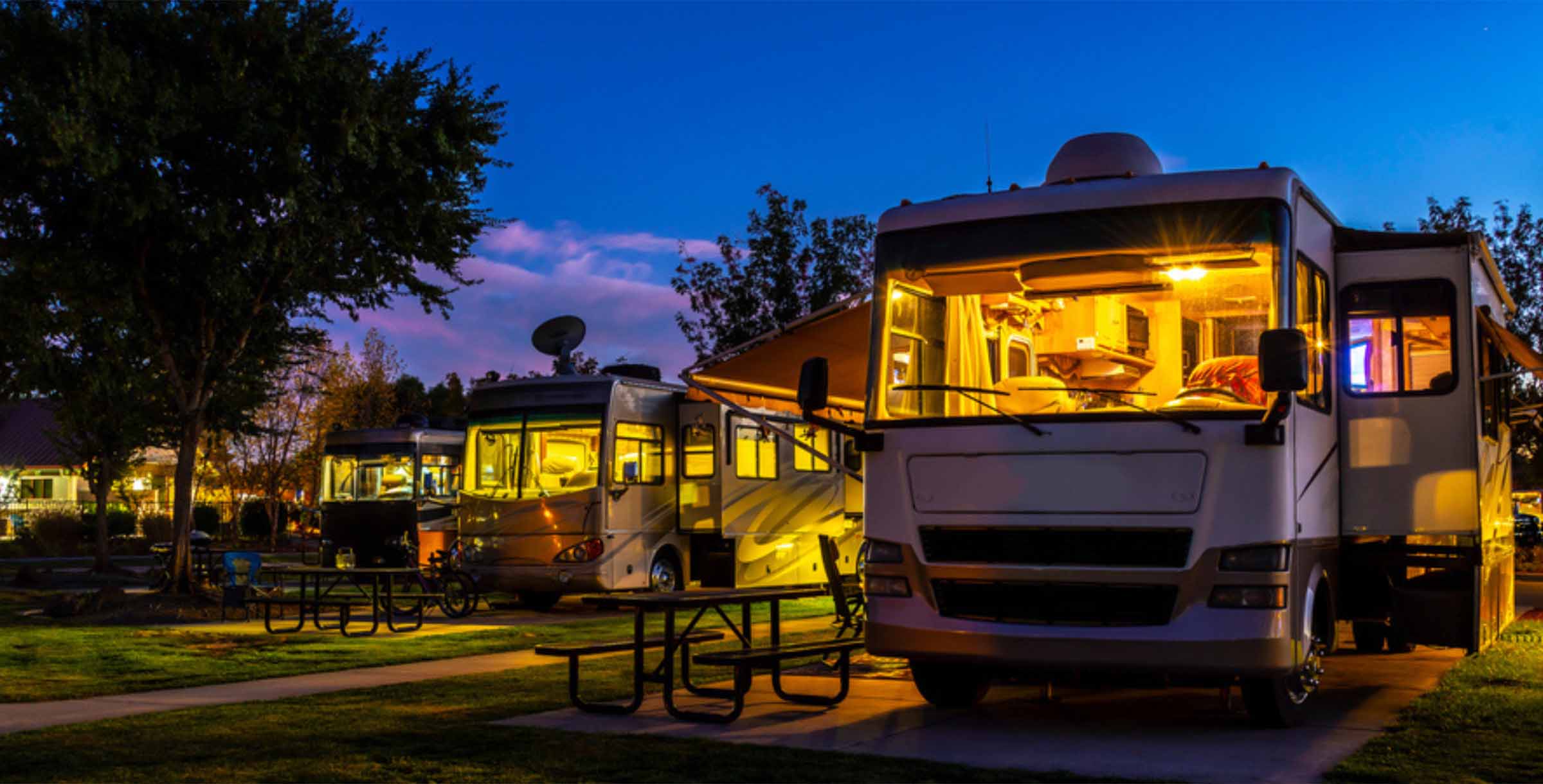 Row of recreational vehicles (RVs) parked at a campsite - arlingtonagency.com